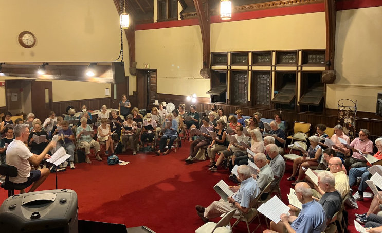 Artistic Director Michael Driscoll leads a rehearsal at First Baptist Church in Newton.